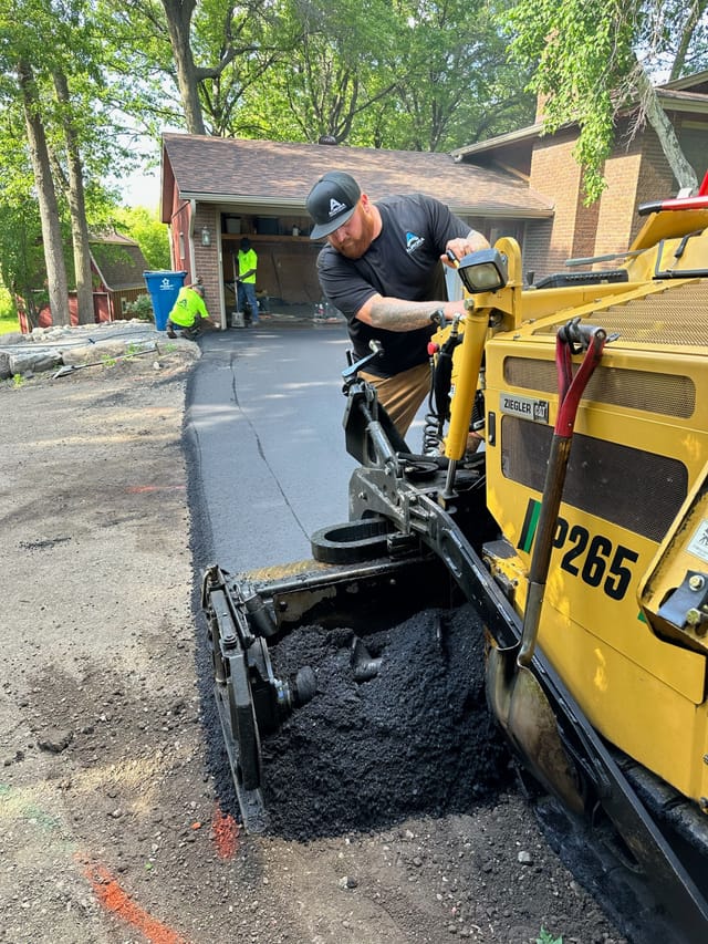 Asphalt driveway repair and replacement taking place in Rogers, Minnesota.